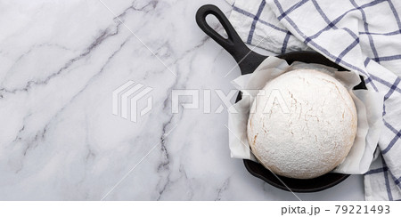 Fresh raw homemade yeast dough resting in cast iron skillet on marble table flat lay. 79221493