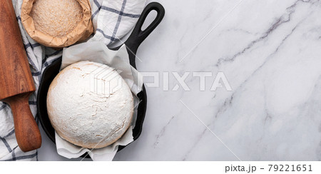 Fresh raw homemade yeast dough resting in cast iron skillet on marble table flat lay. 79221651