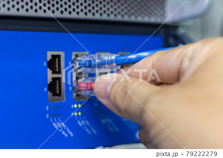 Hand of a man holding The network cables to connect the port of a switch to connect internet network, concept Communication technology Hand of a man holding The network cables to connect the port of a switch to connect internet network, concept Communication technology 79222279