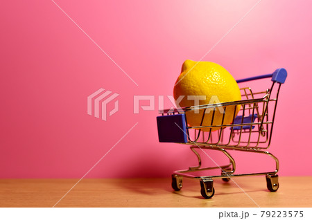 Lemon in a shopping basket on a pink background 79223575