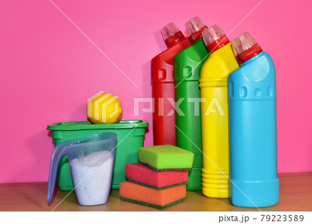 Detergent laundry bottles and sponge for washing on pink background. Household  79223589