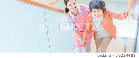 階段を登るシニア女性と介護スタッフ 79224488