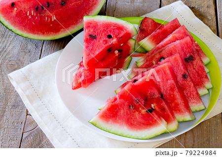 Fresh slices of watermelon on a wooden table. Fresh slices of watermelon on a wooden table. 79224984