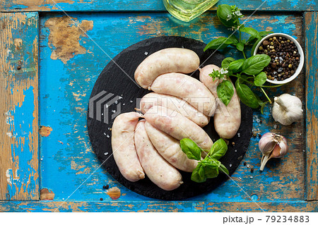 Raw sausages of kutapa on a slate board and spices on a vintage blue wooden background. Top view. 79234883