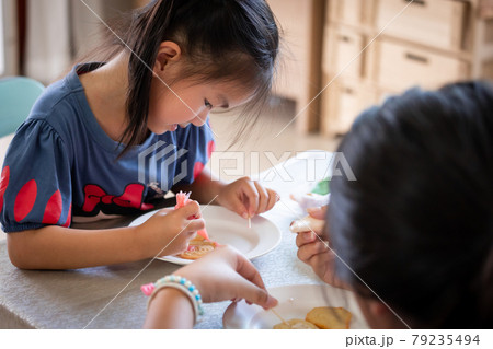 Asian child girl and friends are decorating cookies for party together with fun. DIY homemade kid art and craft concept. 79235494