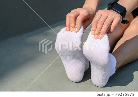 Close up of runner woman trying to do foot stretching for prevent injuries. The benifit of stretching can increasing flexibility performance and reduce risk of injury. Close up of runner woman trying to do foot stretching for prevent injuries. The benifit of stretching can increasing flexibility performance and reduce risk of injury. 79235978