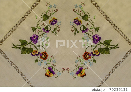 Embroidered napkin with bouquets of brown and purple pansies, blue flowers on curved branches and leaves 79236131