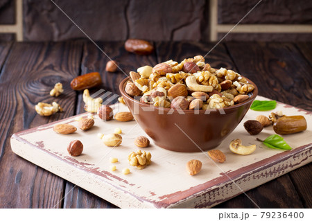 Mix of dried fruits and nuts on a wooden background. The concept of a healthy dessert. Copy space. Mix of dried fruits and nuts on a wooden background. The concept of a healthy dessert. Copy space. 79236400