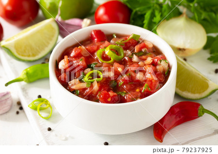 Traditional mexican homemade salsa sauce and ingredients on a white wooden table. Traditional mexican homemade salsa sauce and ingredients on a white wooden table. 79237925