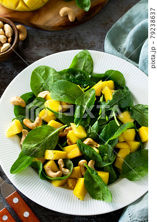 Diet menu, Vegan food concept. Healthy salad with mango, spinach, pecan and vinaigrette dressing on a stone table. 79238637