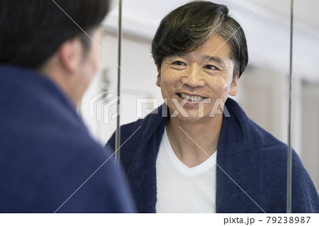 洗面所の鏡を見る笑顔のミドル男性 79238987