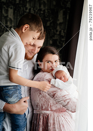 Happy family with a toddler in the bedroom by the window.  79239967