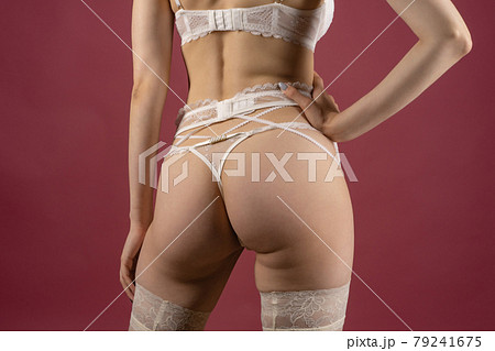 Beautiful young woman in white lace underwear of the bride posing with her back 79241675