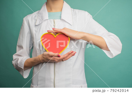 A young female doctor holds a model of a person's heart A young female doctor holds a model of a person's heart 79242014