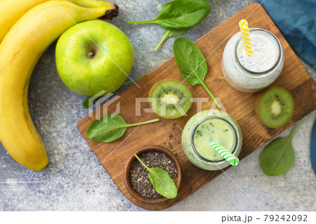 Healthy dieting and nutrition. Vegetarian concept. Blended Green detox vegetable smoothies with organic ingredients on a stone concrete tabletop. Top view flat lay background. Healthy dieting and nutrition. Vegetarian concept. Blended Green detox vegetable smoothies with organic ingredients on a stone concrete tabletop. Top view flat lay background. 79242092