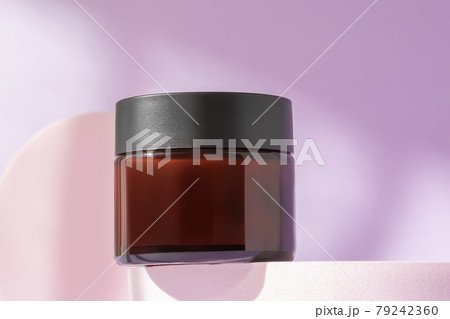 Organic face cream cosmetic mock up on podium, low angle view, copy space. Blank jar of luxury lotion in brown bottle standing on pedestal showcase. Beauty packaging mockup 79242360