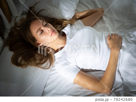 Pretty girl sleeping deeply in bed in morning Pretty girl sleeping deeply in bed in morning 79242680
