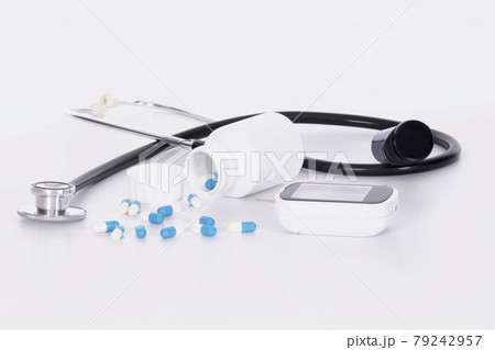 Close up of stethoscope, blood glucose monitor and spilled capsules:Diabetes and healthcare concept. 79242957