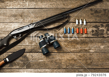 Hunting equipment on old wooden background including rifle, knife, binoculars and cartridges Hunting equipment on old wooden background including rifle, knife, binoculars and cartridges 79243076