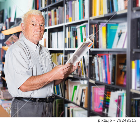 Old customer is choosing book for reading in free time 79243515