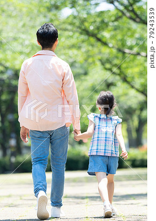 手をつないで歩く親子の後ろ姿の写真素材