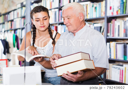 Nice old man with girl are reading books Nice old man with girl are reading books 79243602