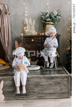 Happy funny two brothers bake christmas cookies near tree. 79249507