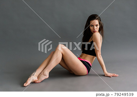 Posing fitness seductive woman isolated on grey background Posing fitness seductive woman isolated on grey background 79249539