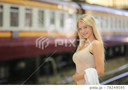young woman waiting in vintage train, relaxed and carefree at the station platform in Bangkok, Thailand before catching a train. Travel photography. Lifestyle. 79249595