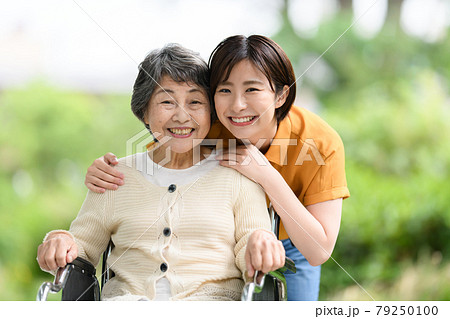 シニア女性　若い女性　新緑　介護　笑顔　車椅子 79250100