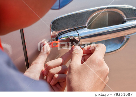 Close-up Of Person's Young Man Locksmith Hand Opening Bronze Car Door With Lock picker. 79251087