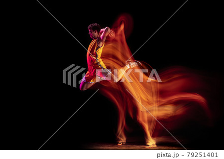 Young Caucasian basketball player training isolated on black background in mixed neon lights. 79251401