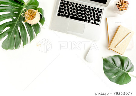 Flat lay home office desk. Female workspace with laptop, tropical palm leaves Monstera, accessories on white background. Top view feminine background Flat lay home office desk. Female workspace with laptop, tropical palm leaves Monstera, accessories on white background. Top view feminine background 79253077