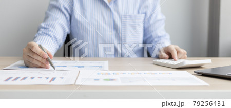 Asian business women are analyzing graphs, financial statistics and calculating corporate returns in private offices, Market research reports and income statistics, Financial and Accounting concept. 79256431