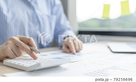 Young Asian businesswoman presses a calculator to calculate income tax and corporate income in a private office, Finance, Accounting, Tex, Statistical graphs of marketers investing in real estate. Young Asian businesswoman presses a calculator to calculate income tax and corporate income in a private office, Finance, Accounting, Tex, Statistical graphs of marketers investing in real estate. 79256696