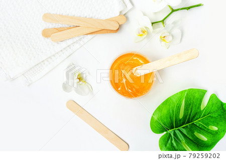 Sugar paste or wax honey in a transparent jar on a white background. Sugaring. Depilation and beauty concept. Waxing. 79259202