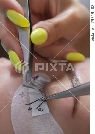 Beautiful Woman with long eyelashes in a beauty salon. Eyelash extension procedure. Lashes close up. Beautiful Woman with long eyelashes in a beauty salon. Eyelash extension procedure. Lashes close up. 79259382