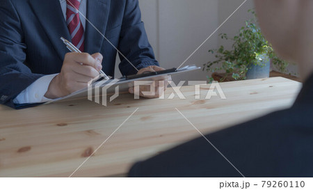 クリップボード上の書類に書き込む男性。商談・面談イメージ 79260110