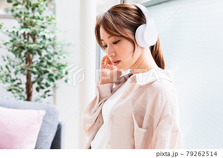 ヘッドフォンで音楽に聴き入る若い女性 79262514