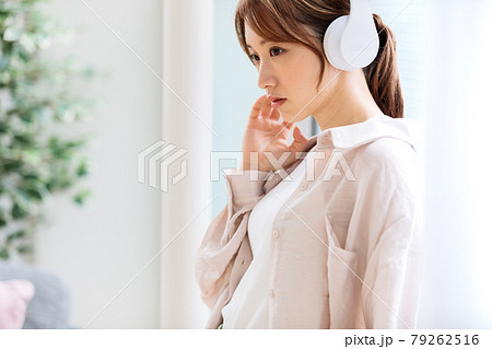 ヘッドフォンで音楽に聴き入る若い女性 79262516