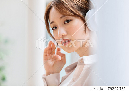 ヘッドフォンで音楽に聴き入る若い女性 79262522