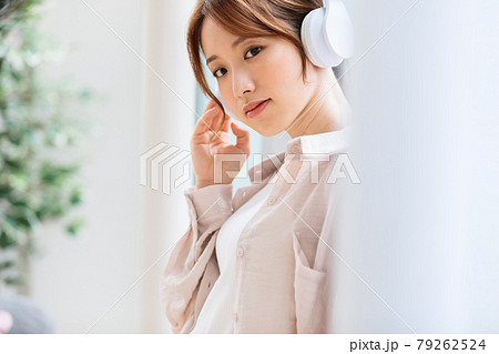 ヘッドフォンで音楽に聴き入る若い女性 79262524