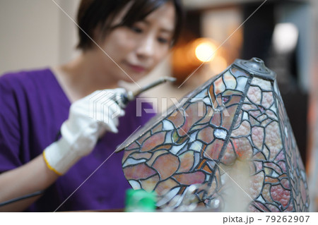 ステンドグラスのランプを作る女性 79262907