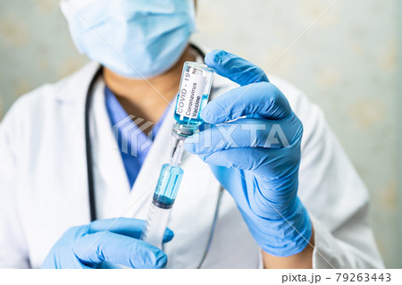 Doctor holding syringe with vaccine development medical for doctor use to treat illness patients Covid-19 coronavirus vaccine at hospital. Doctor holding syringe with vaccine development medical for doctor use to treat illness patients Covid-19 coronavirus vaccine at hospital. 79263443