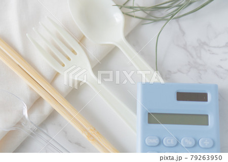 割りばしとプラスチック製カトラリーと電卓 79263950