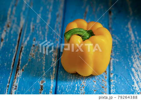 Yellow bell pepper on blue wooden table 79264388