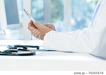 スマホを操作する医師の手元 79265678