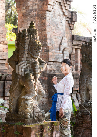 バリ島の伝統寺院にいる伝統衣装(クバヤ)を着た女性 79266101