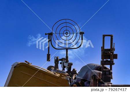 fragment of an anti aircraft machine gun, a round sight is aimed at clouds sky 79267437