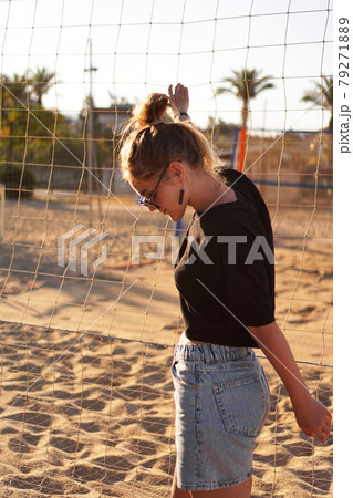 Portrait of attractive woman near volleyball net on the beach. Vertical photo Portrait of attractive woman near volleyball net on the beach. Vertical photo 79271889
